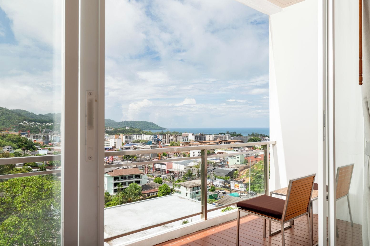 Un balcón con vista a un paisaje urbano y montañas.