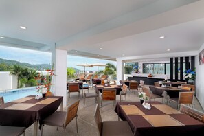 Ein Restaurant mit Sitzgelegenheiten auf dem Dach, das einen Pool und eine Bar mit Blick auf die Stadt bietet.