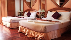 Habitación de hotel con dos camas, cabeceros de madera y un espejo.