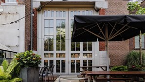 An outdoor patio area with a table, chairs, and umbrellas.
