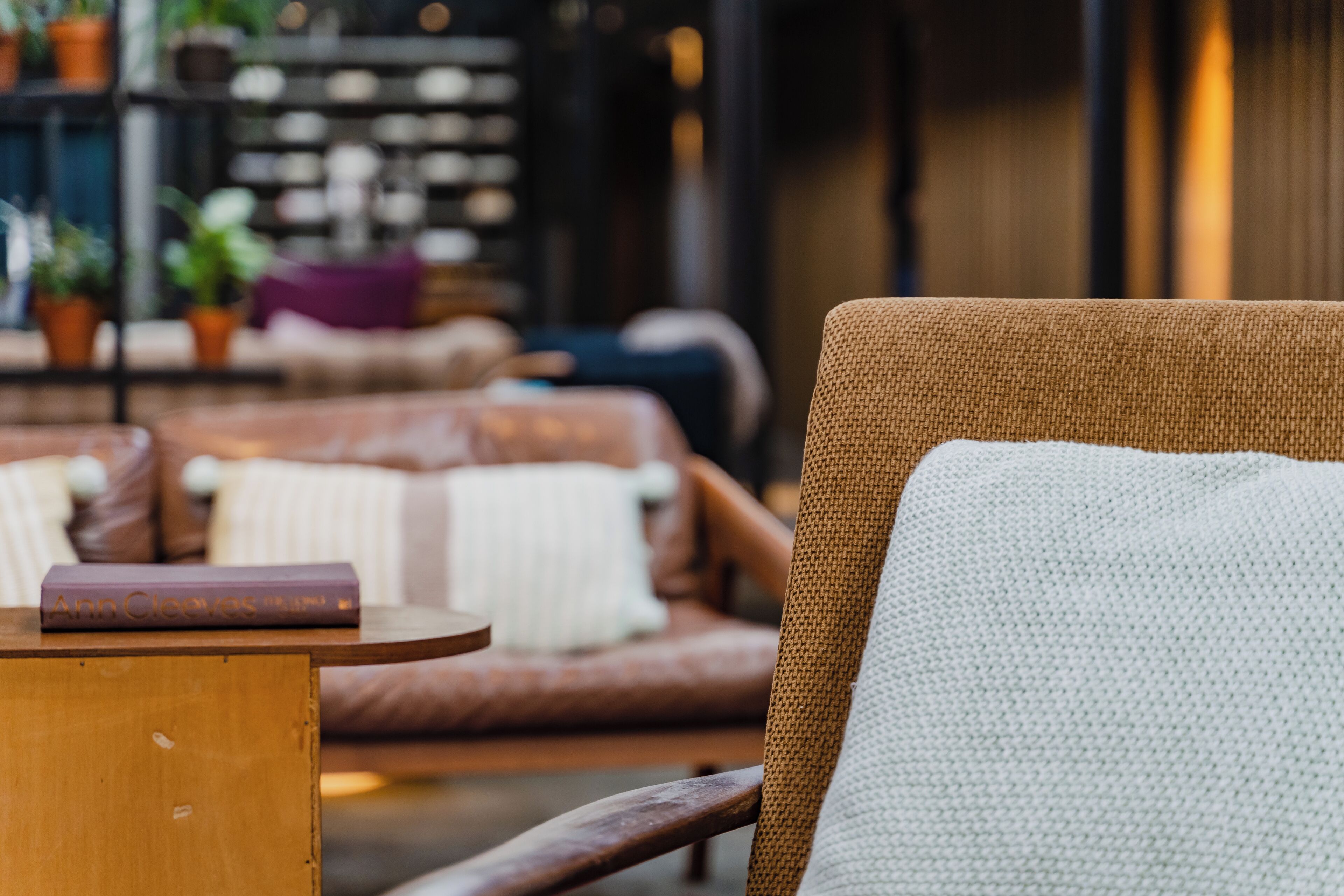 A cozy seating area with a brown chair and a round wooden table.