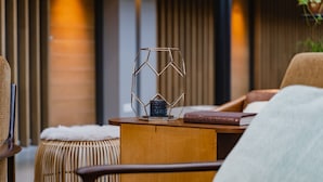 A cozy seating area with a wooden table, a woven stool, and a chair.