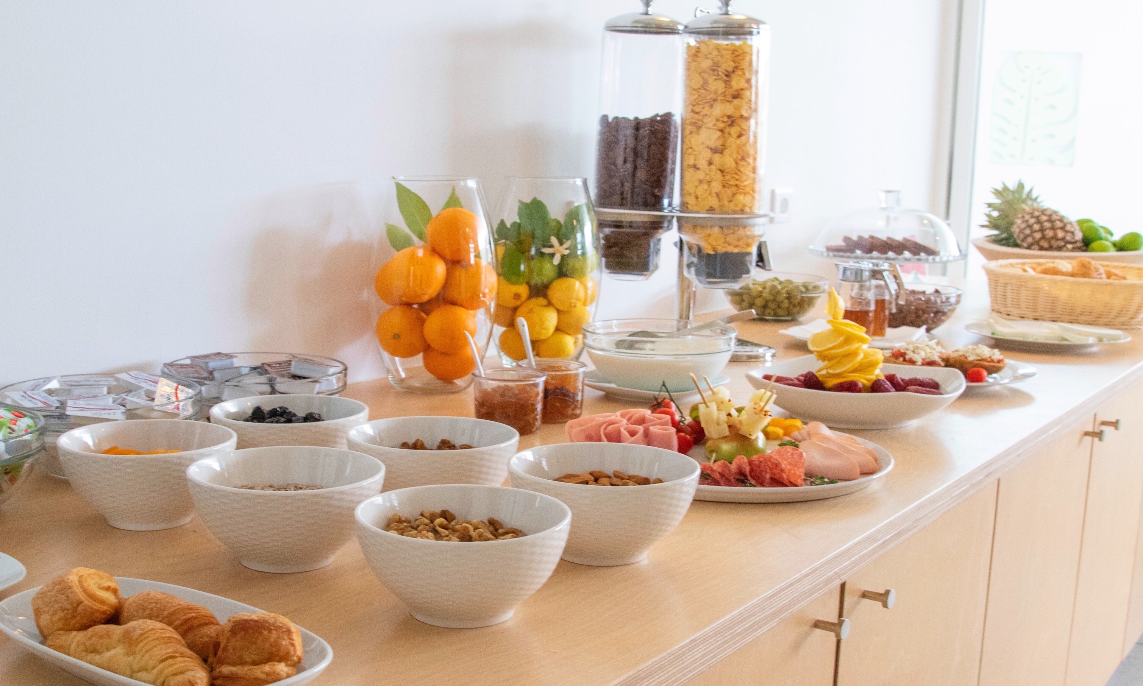 A buffet with various food items including fruits, nuts, and pastries.