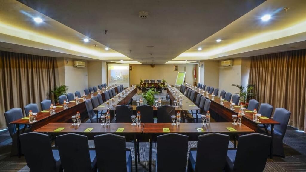 A conference room with a long table, multiple chairs, and water bottles.