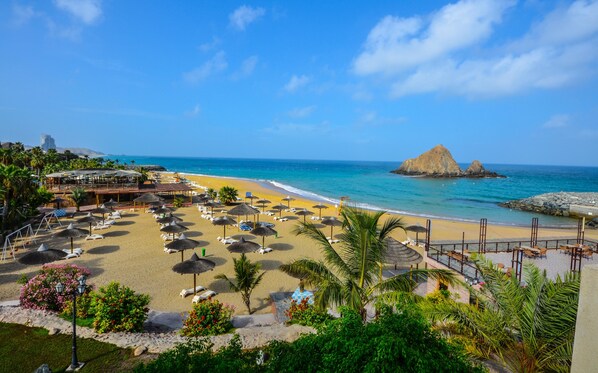 A beach resort with sun loungers, umbrellas, and a view of the ocean. - Sandy Beach Hotel and Resort (Al Aqah)
