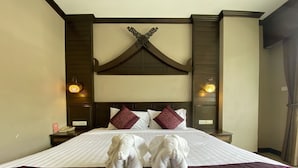 A hotel room with a large bed, two bedside lamps, a decorative wall piece, and a red throw blanket. - Lemongrass Hotel (Patong)