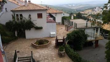 Un patio con un jardín pequeño, una escalera y vistas del paisaje circundante.