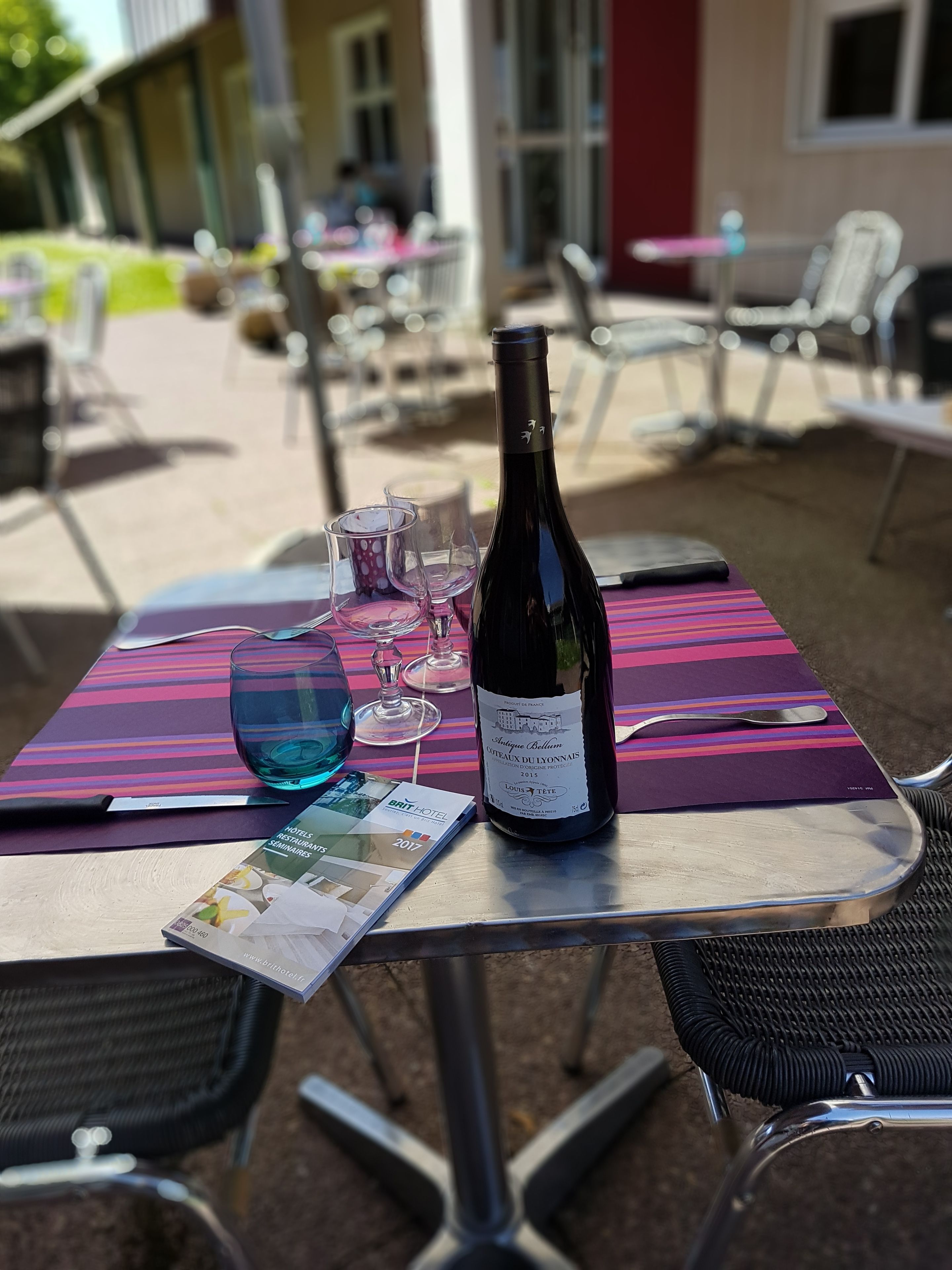 A table with a bottle of wine, glasses, and a menu.