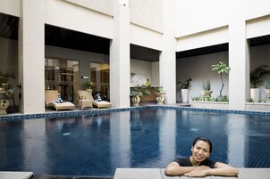 A pool area with lounge chairs and potted plants.