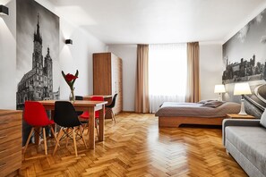 Suite estudio familiar, 1 cama matrimonial y sofá cama, vista a la ciudad | Área de sala de estar | Televisión 