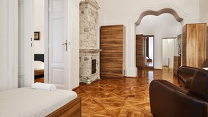 Um quarto com piso de madeira, uma cama, um guarda-roupa e uma lareira.