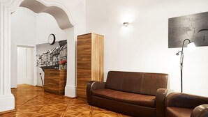 Uma sala de estar com um sofá de couro marrom, um armário de madeira e um relógio fixado na parede.