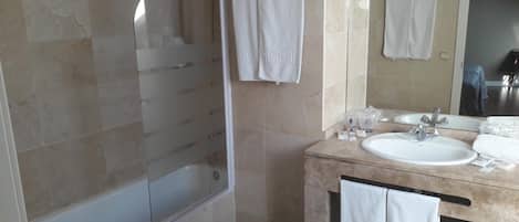 Un bagno con vasca, doccia e lavandino con specchio.