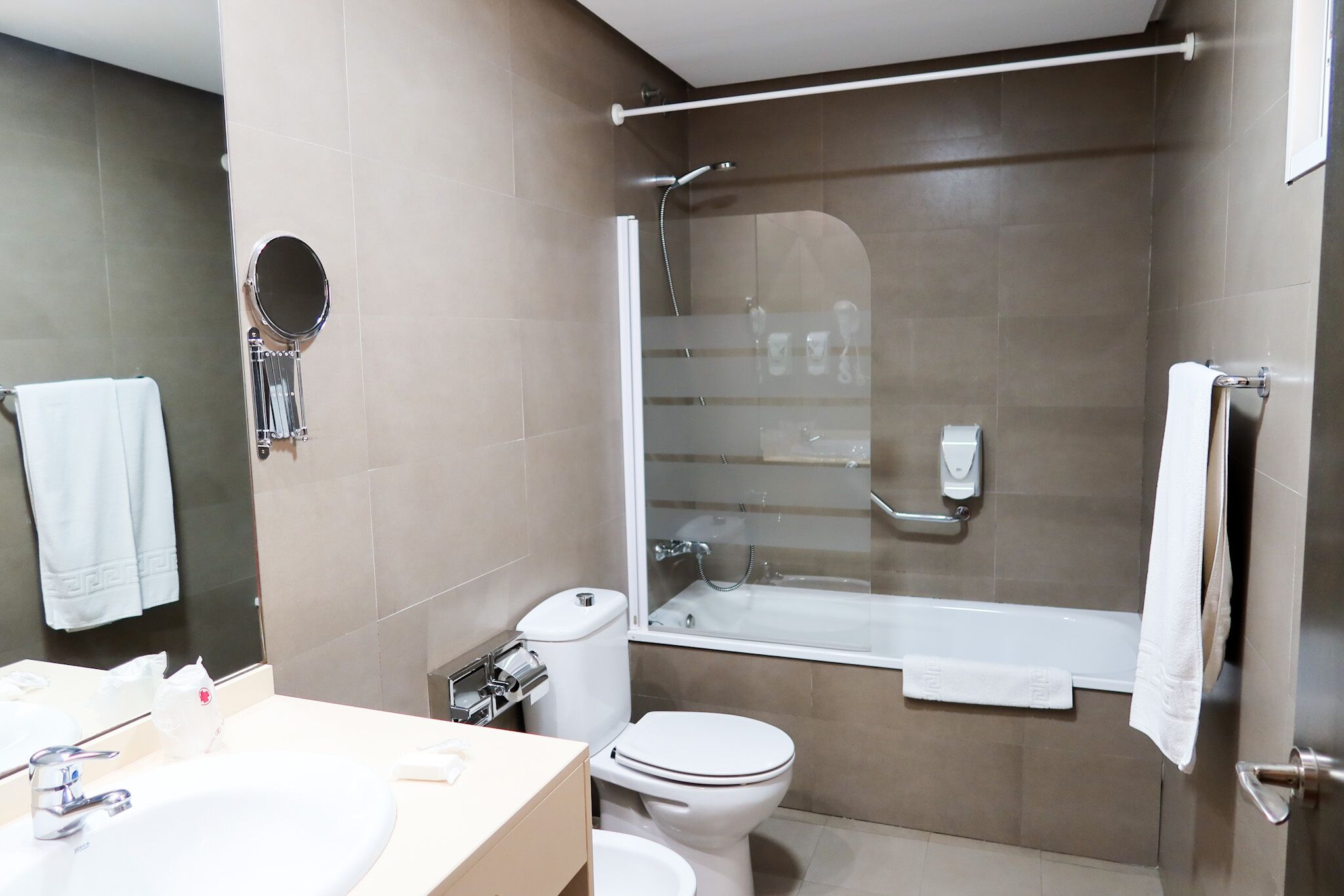 A modern bathroom with a bathtub, toilet, and sink.