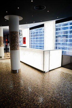 A reception area with a marble counter, a tiled floor, and a large window with a view of the outside. - Hotel Benetússer (Benetusser)