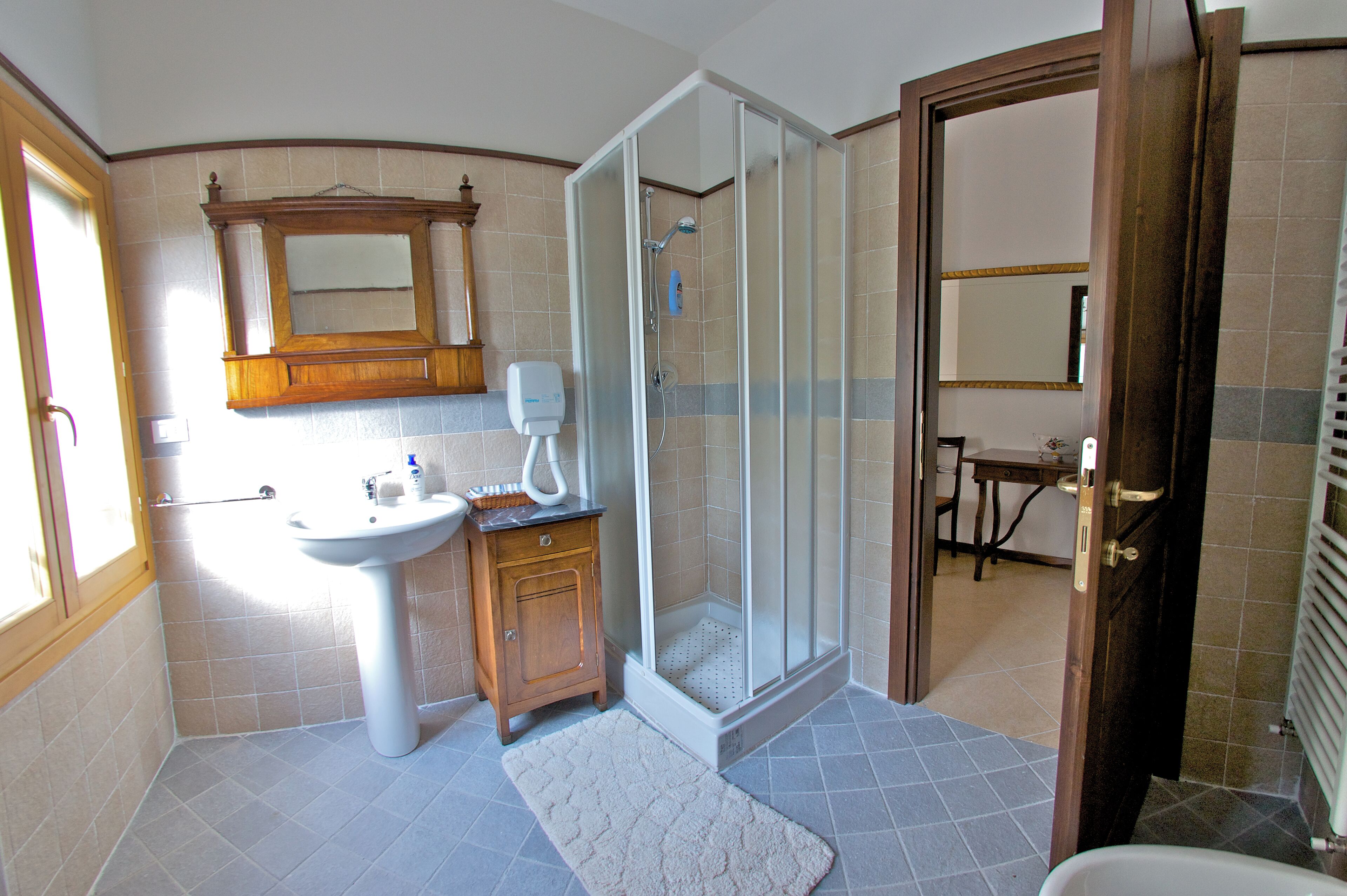 Een badkamer met een wastafel, spiegel, douche en toilet.