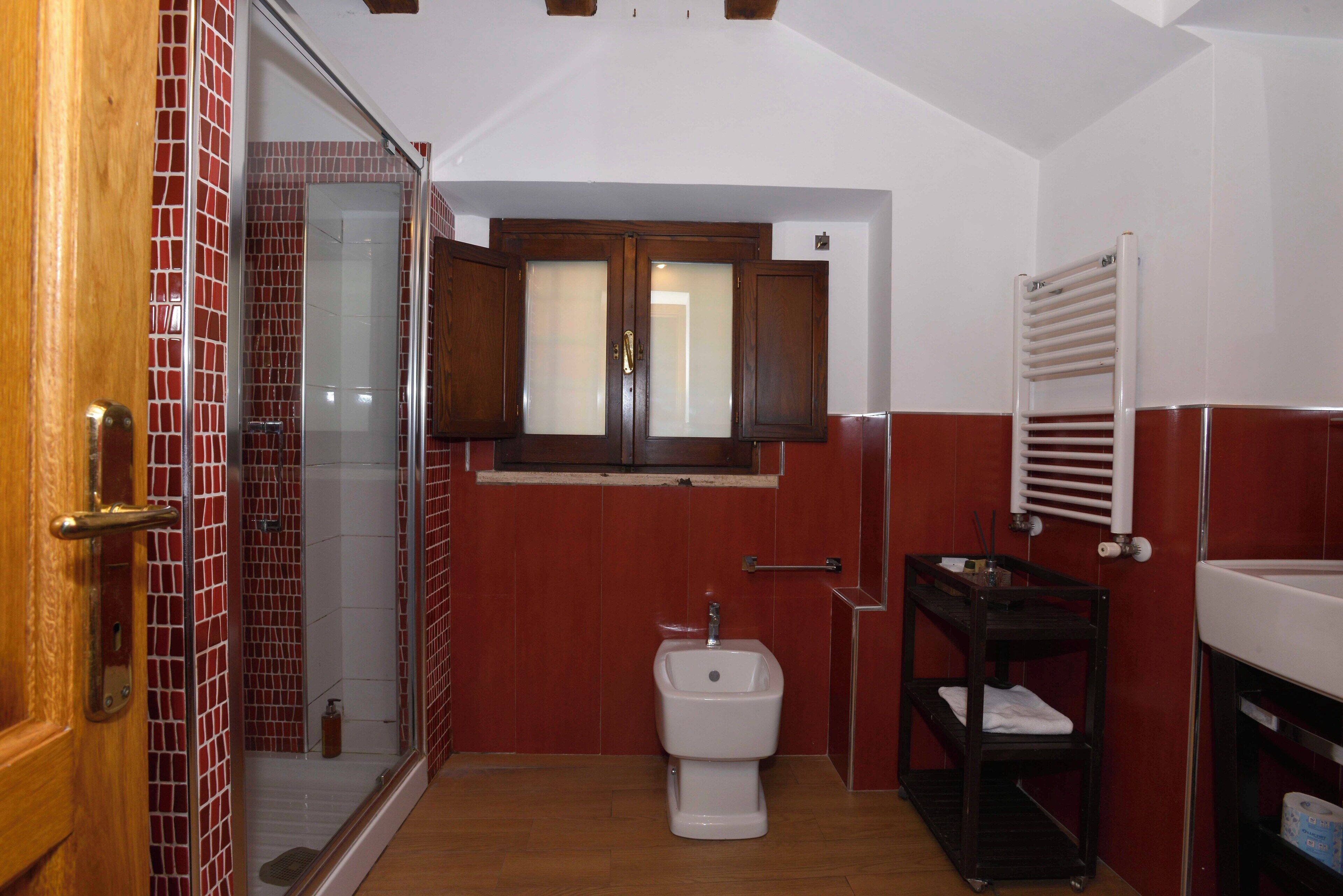 A bathroom with a shower, toilet, and sink.