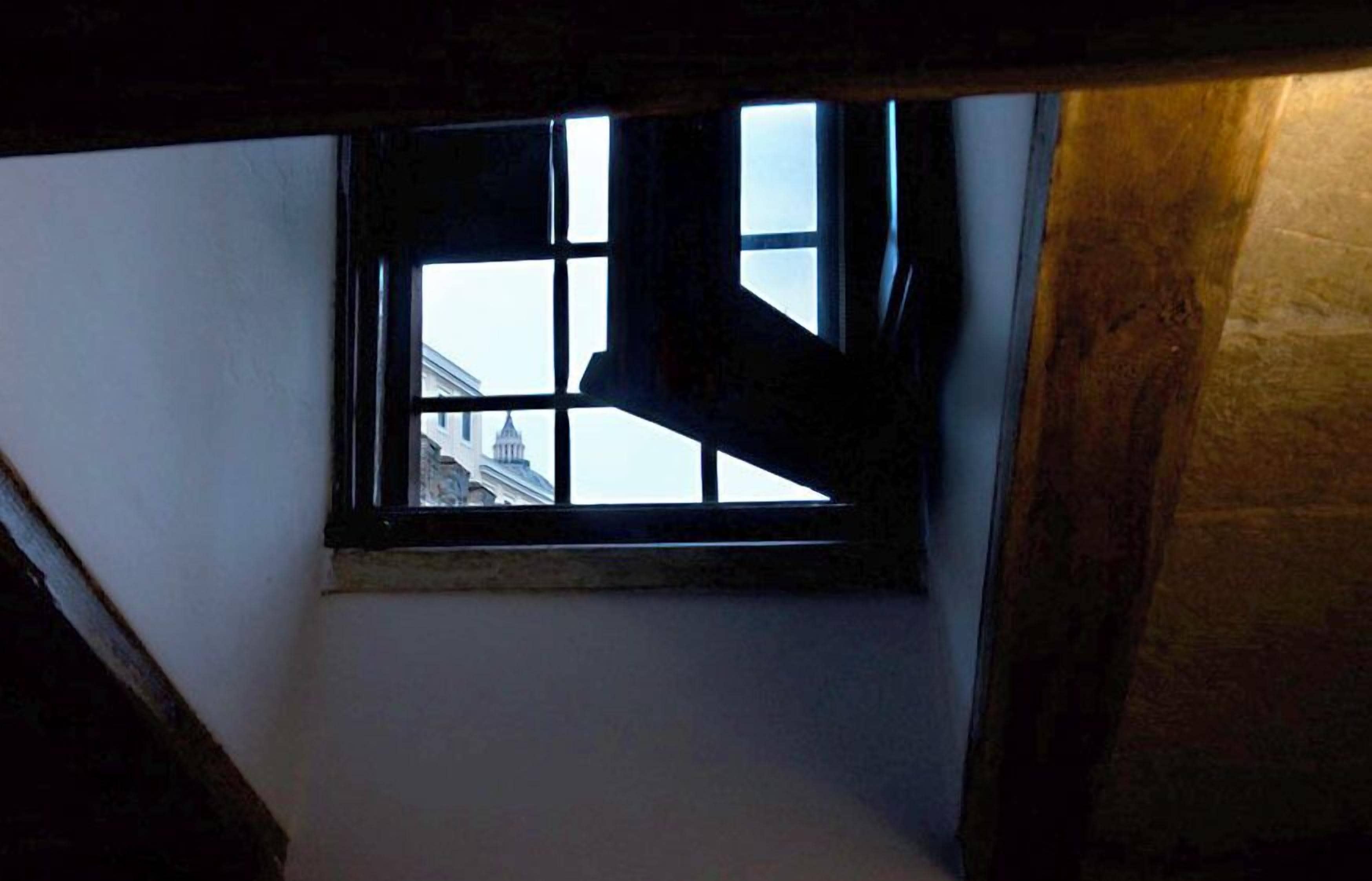 A narrow window with a view of a building in the background.