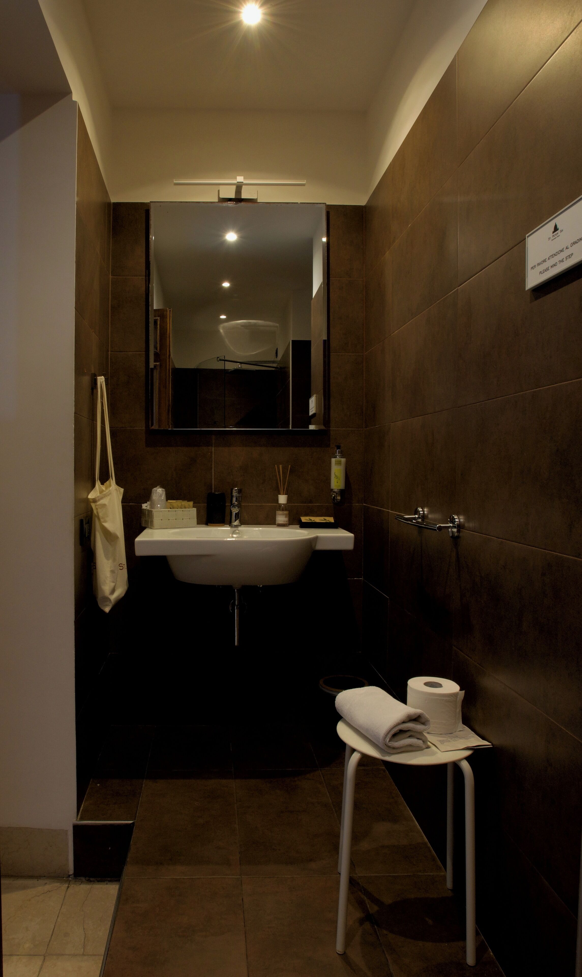Ein modernes Badezimmer mit großem Waschbecken, Spiegel und Handtuchhalter.
