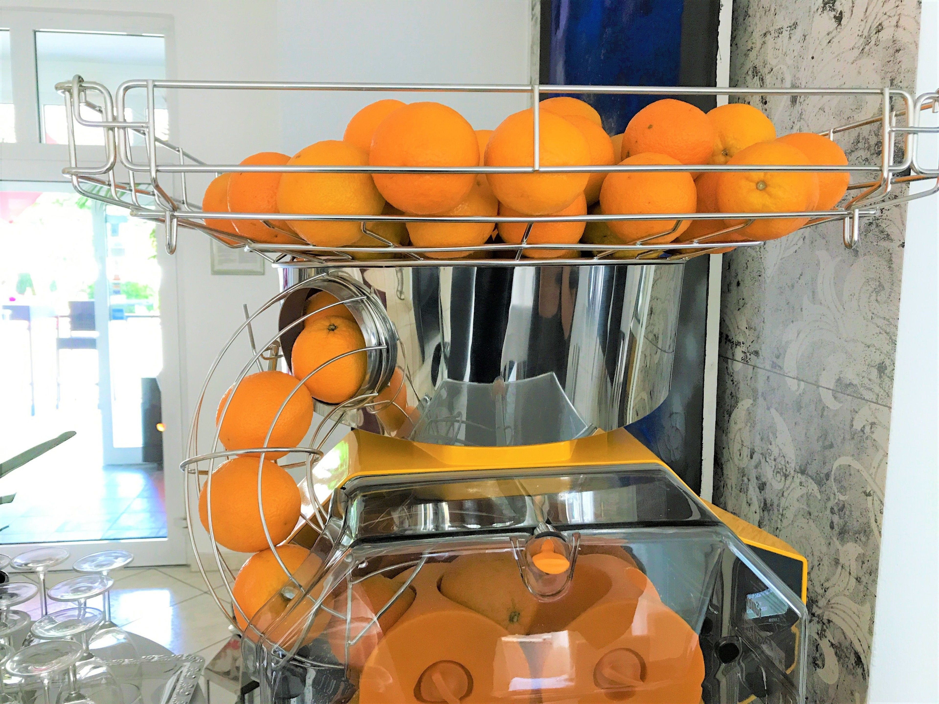A kitchen with a fruit display and a sink.