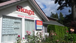A building with a sign that reads "Skagit Newly Renovated" and another sign stating "Opening New Building".