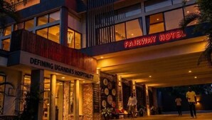 A hotel with a modern design, a prominent sign, and a well-lit entrance. - Fairway Hotel & Spa (Kampala)