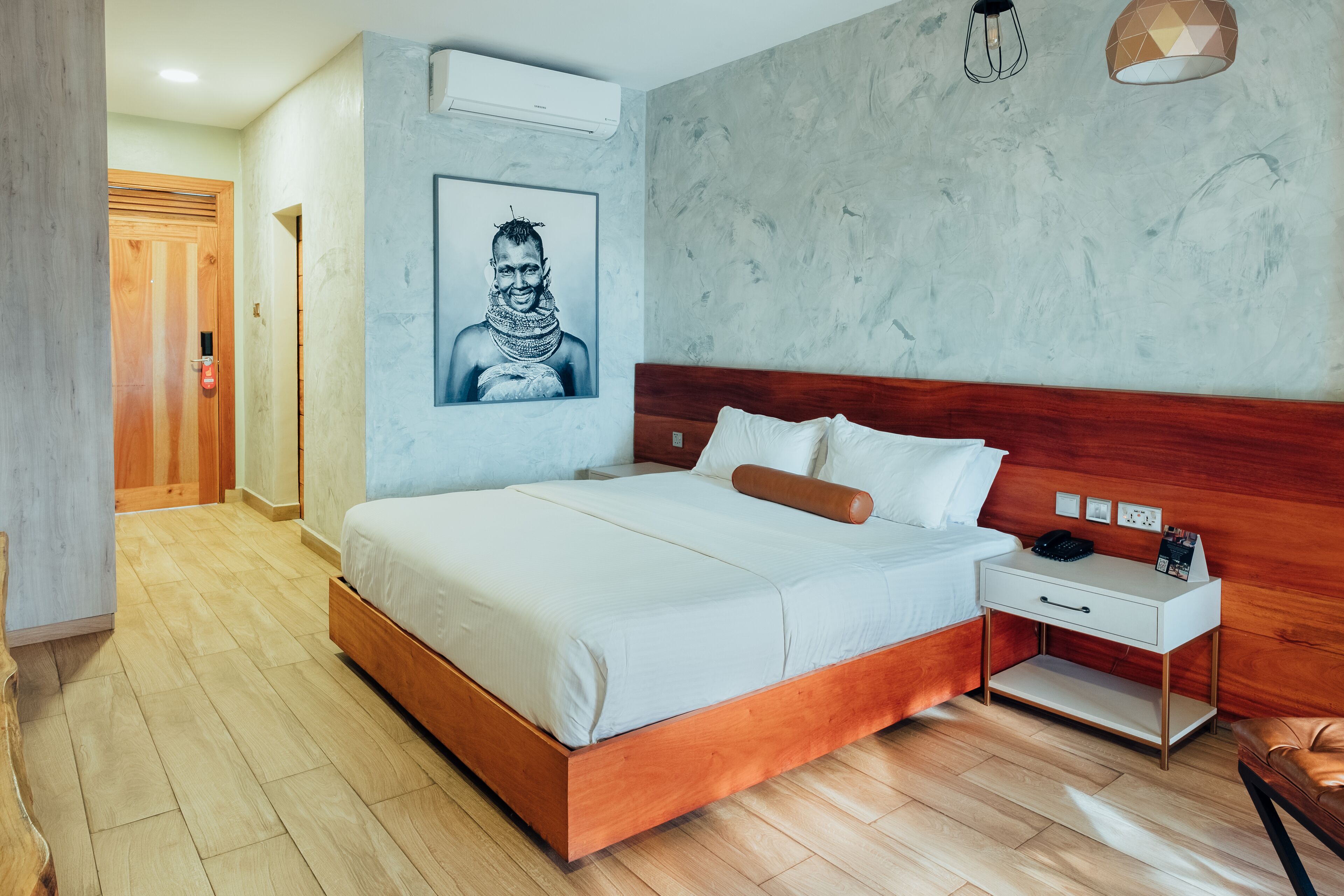 Un dormitorio con una cama de madera, una mesita de noche y un aire acondicionado instalado en la pared.