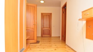 Un corridoio con porte in legno e un telefono su un mobiletto.