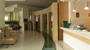 A modern lobby with a curved reception desk, seating area, and a glass partition. - Cathrin Hotel Rhodes By Anayia All Inclusive Resorts (Rhodes)
