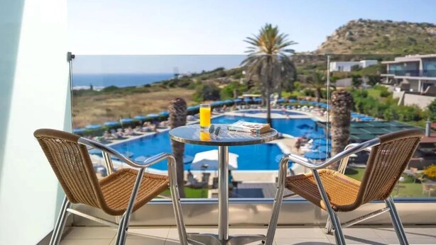 A balcony with a view of a pool and a mountain. - Cathrin Hotel Rhodes By Anayia All Inclusive Resorts (Rhodes)