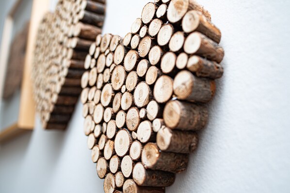 A wall decorated with wooden logs arranged in a heart shape.