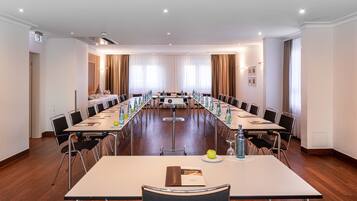 A conference room with a long table, chairs, and a projector.
