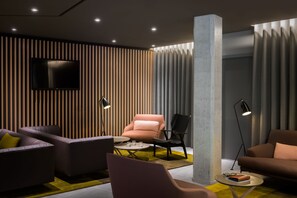 Relax in this stylish living room with a flat-screen TV, comfortable seating area, and a floor lamp.