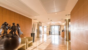 A modern lobby with a wooden wall, a reception desk, and a large sculpture. - Le Saint Paul Hôtel (Nice)