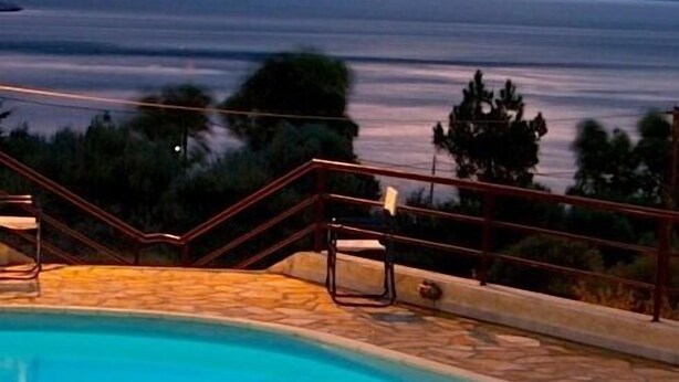 A swimming pool with a view of mountains and a sunset. - Amalia Residences (Marathon)