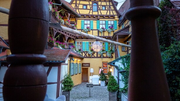 A traditional half-timbered building with a cobblestone pathway leading to the entrance. - Hezelhof Hotel (Dinkelsbuehl)