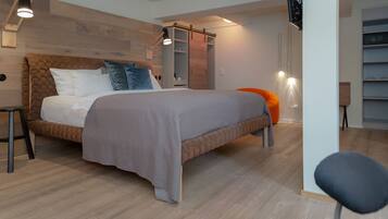 A modern bedroom with a large bed, wooden headboard, and a sliding closet.