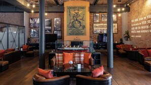 A spacious lounge area with leather seating, a central table, and a large poster of the White Star Line. - Titanic Hotel Liverpool (Liverpool)