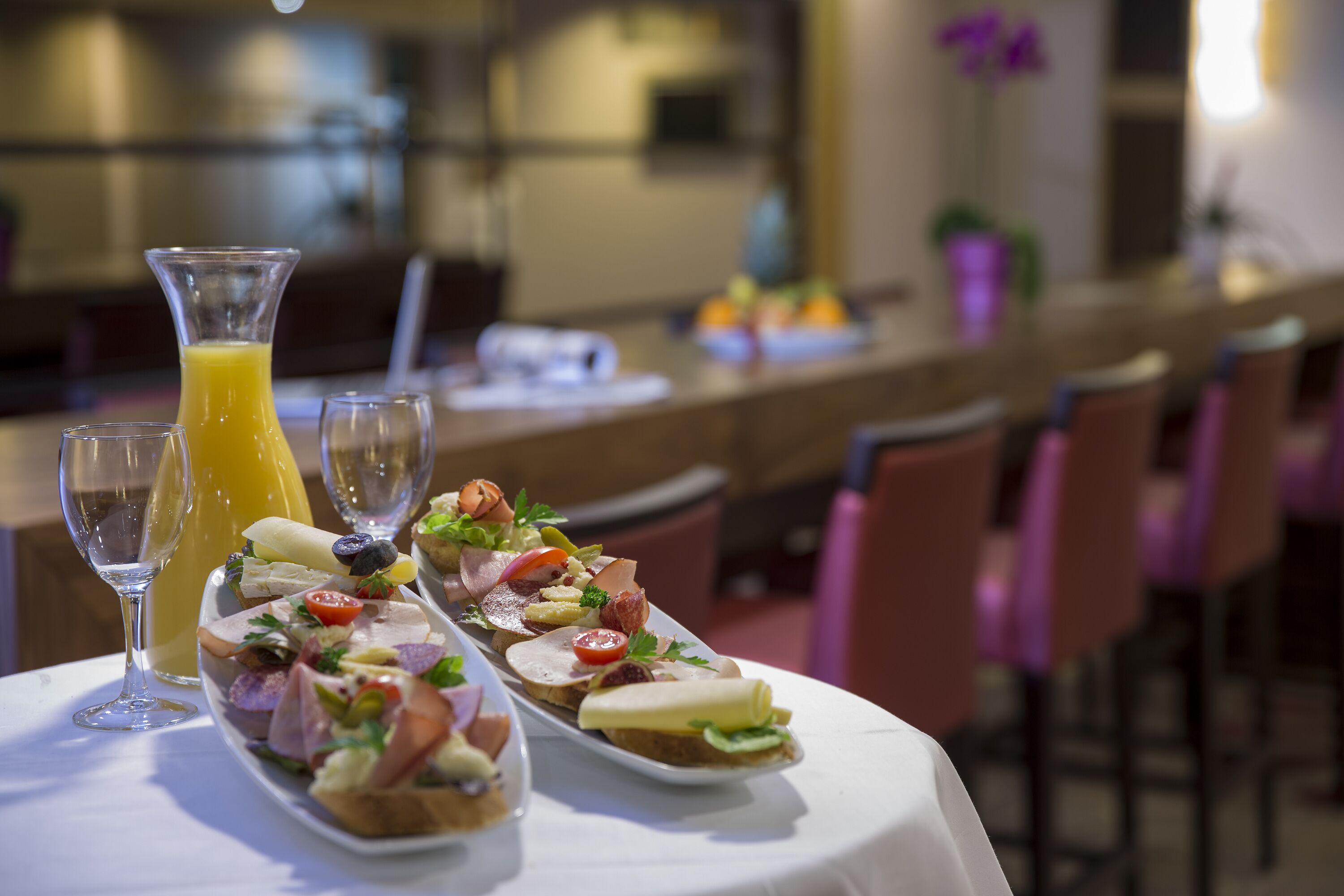 A table with a variety of appetizers and a glass of orange juice.