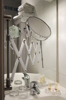 A bathroom with a modern vanity, a mirror, and a towel rack.