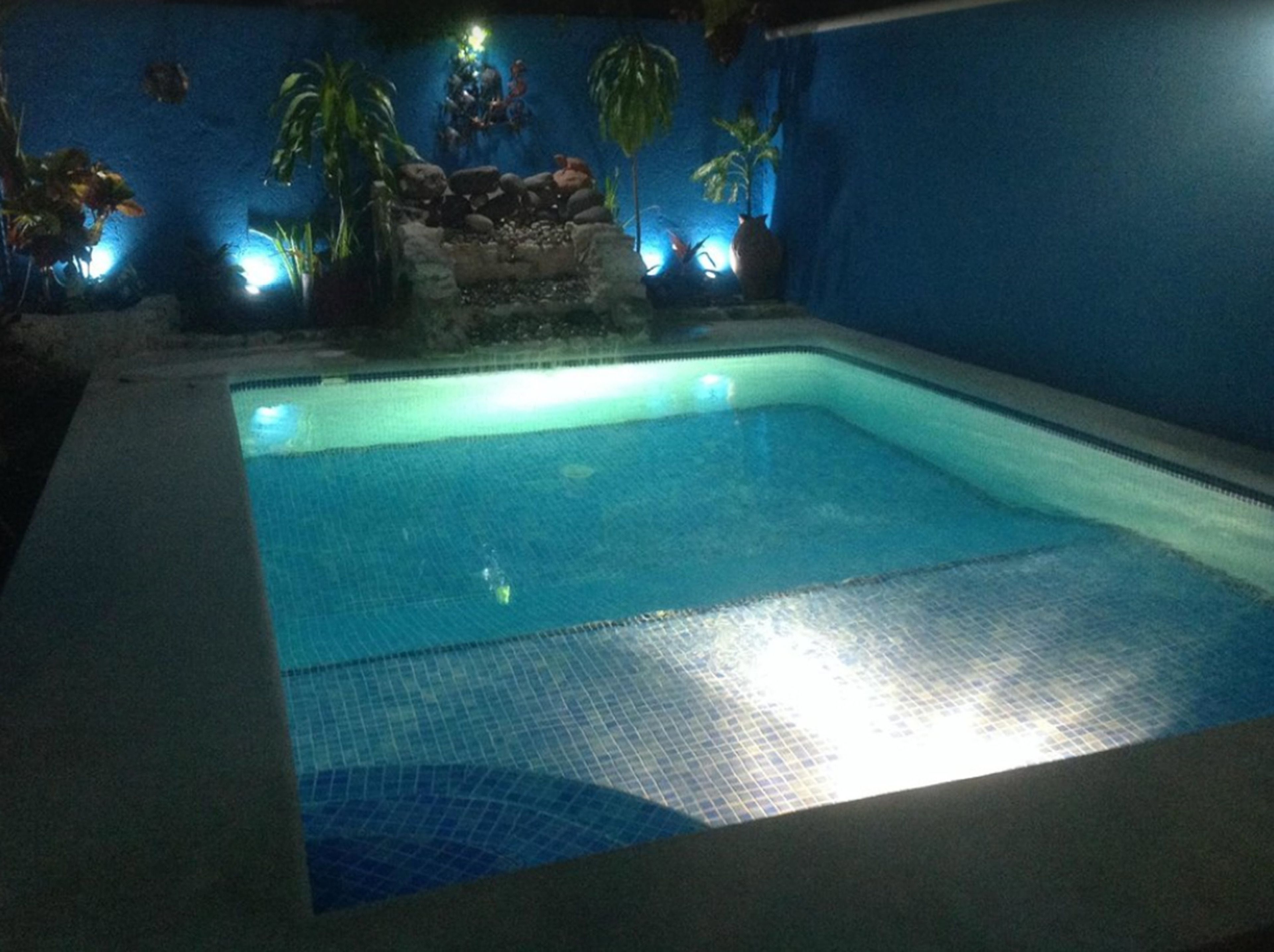 Una piscina coberta rectangular amb aigua blava cristal·lina, envoltada per un sòl i parets de rajola.