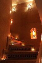 Una escalera con baldosas estampadas y apliques de luz en la pared.