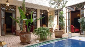 A pool area with potted plants and outdoor seating. - Riad Belle Époque (Marrakech)