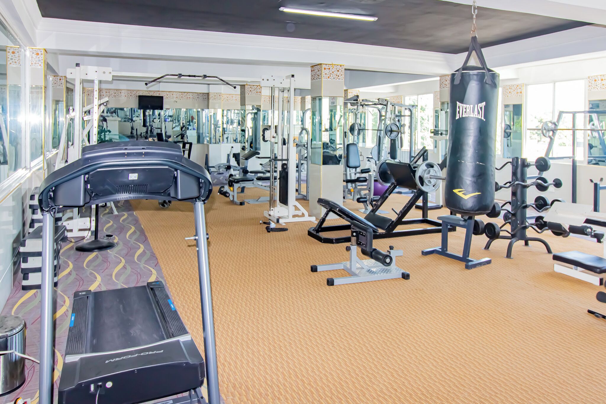 A gym with cardio equipment, weight machines, and a punching bag.