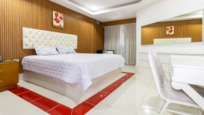 Quarto moderno com uma cama grande, uma escrivaninha e uma cadeira.