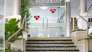 Placa de restaurante com porta de vidro e corações decorativos.