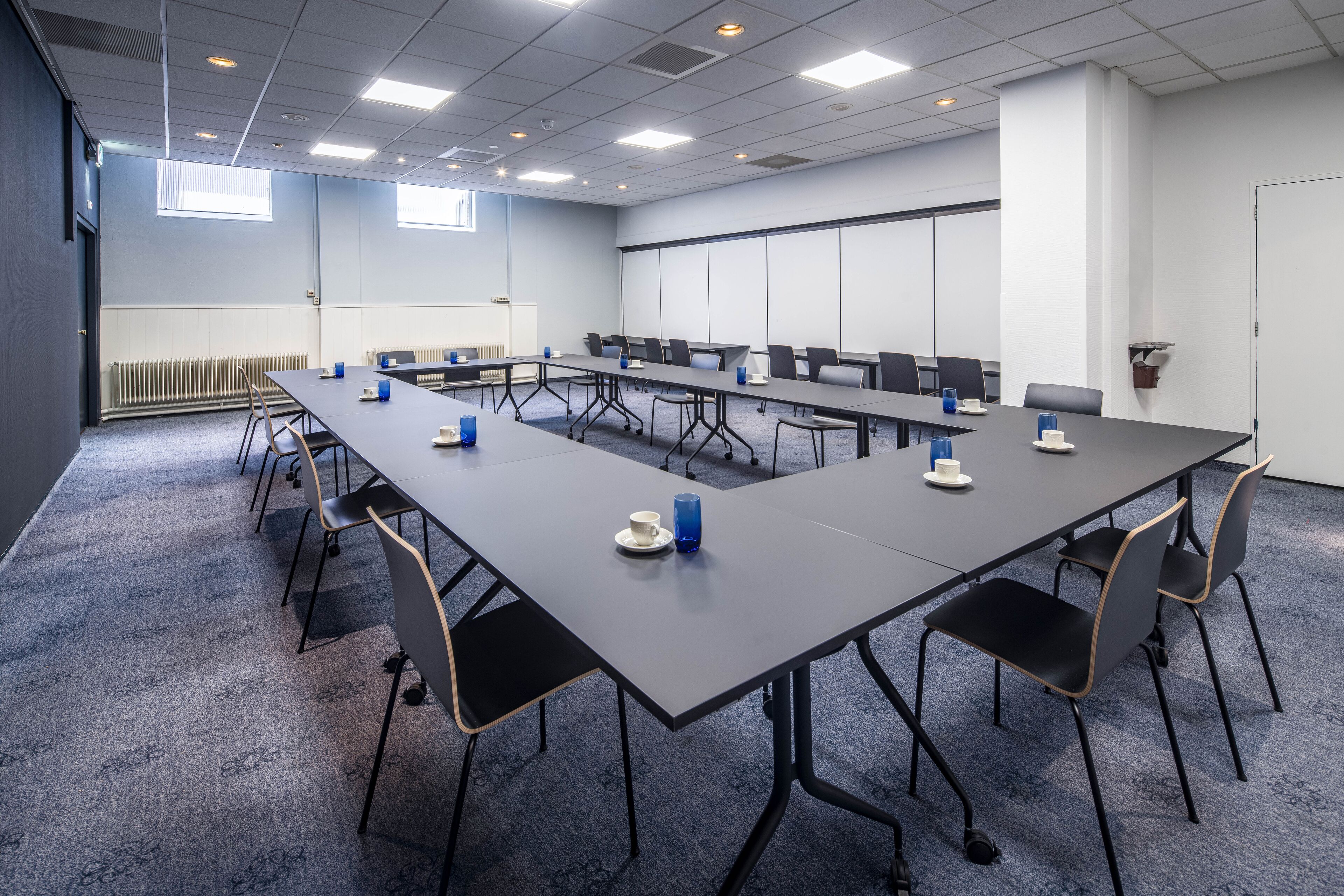 A conference room with a long table, chairs, and a whiteboard.