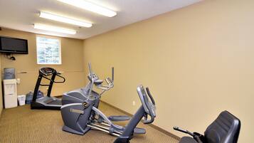 A fitness room with an elliptical machine, a stationary bike, and a treadmill.