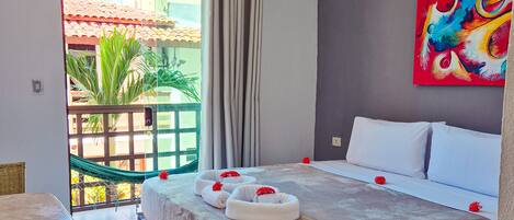 Una habitación de hotel con cama, una mesa de comedor, una silla y vistas al exterior.