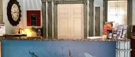 A reception area with a mural depicting an underwater scene, a clock, and a door with a glass panel.